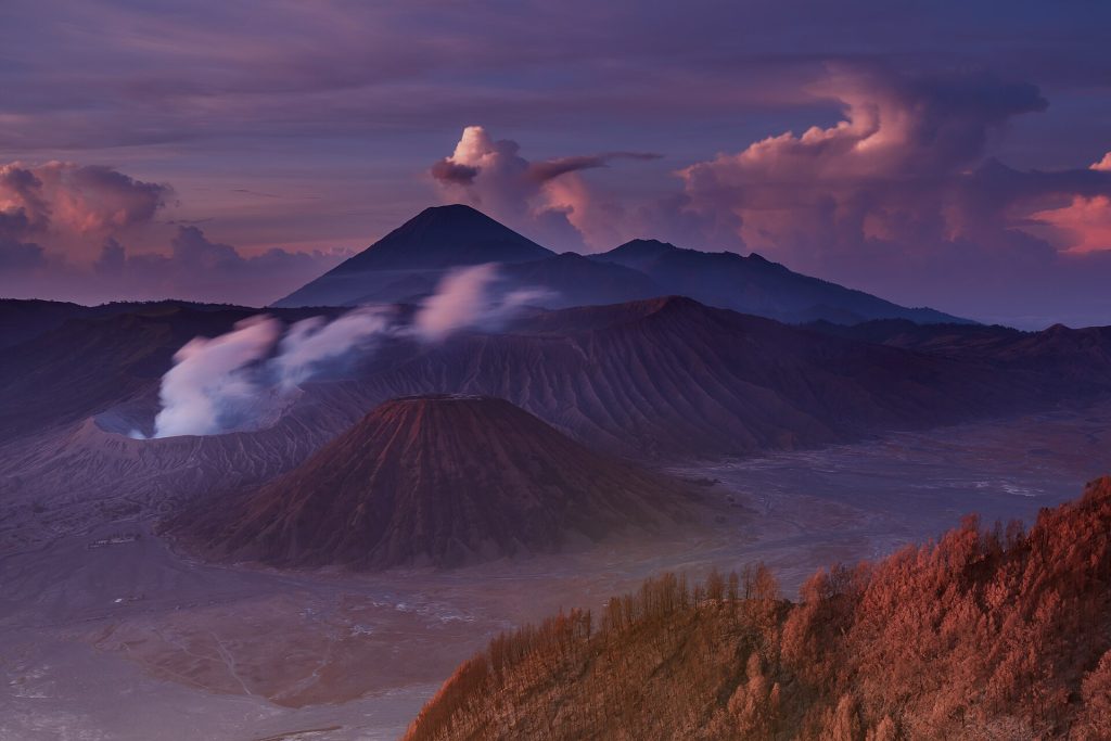 Lever de soleil sur le mont Bromo fumant, la mer de sable et le mont Semeru en arrière-plan, à Java.