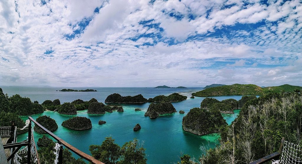 Vue aérienne du point de vue de Piaynemo à Raja Ampat : îlots karstiques couverts de végétation posés sur un lagon turquoise.